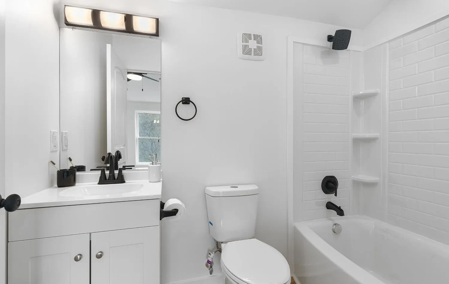 Completed Garfield Avenue bathroom with white vanity and tub surround