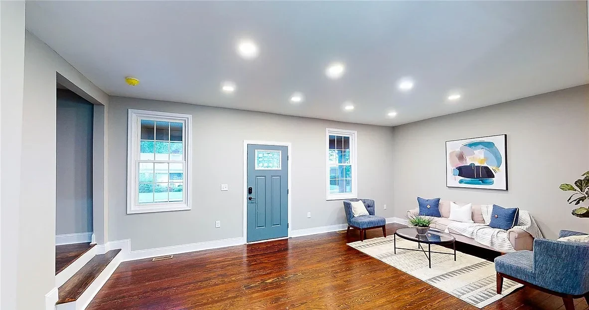 Completed Lynchburg Avenue living room with restored hardwood floors and recessed lighting