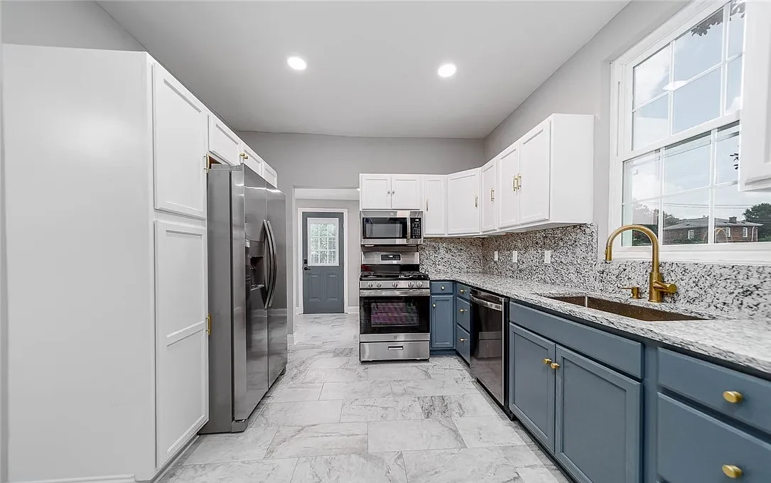 Completed Lynchburg Avenue kitchen with white and blue cabinets and stainless appliances
