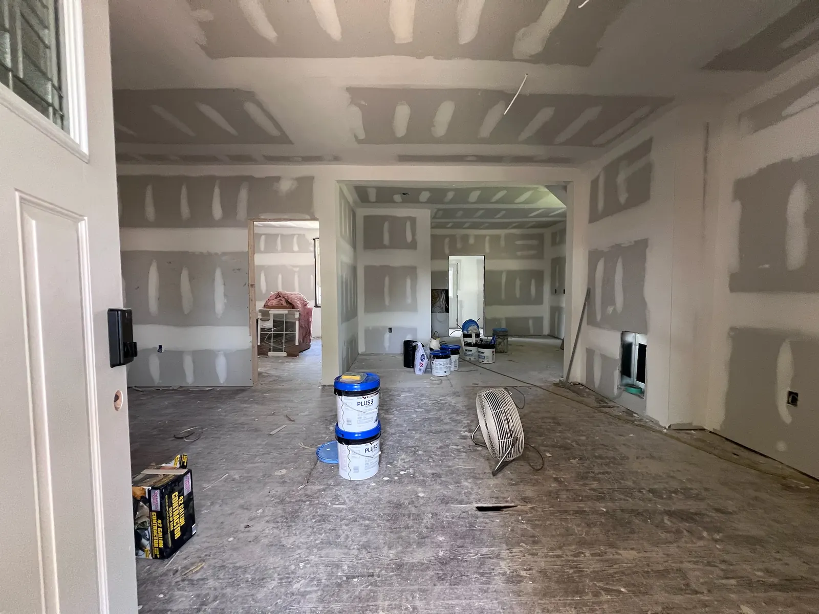 Main living area during drywall finishing and floor preparation