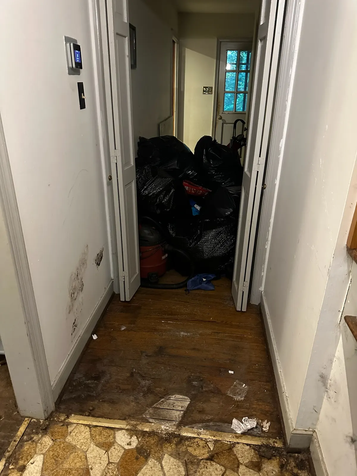 Hallway at Kingsland Rd before renovation, filled with debris