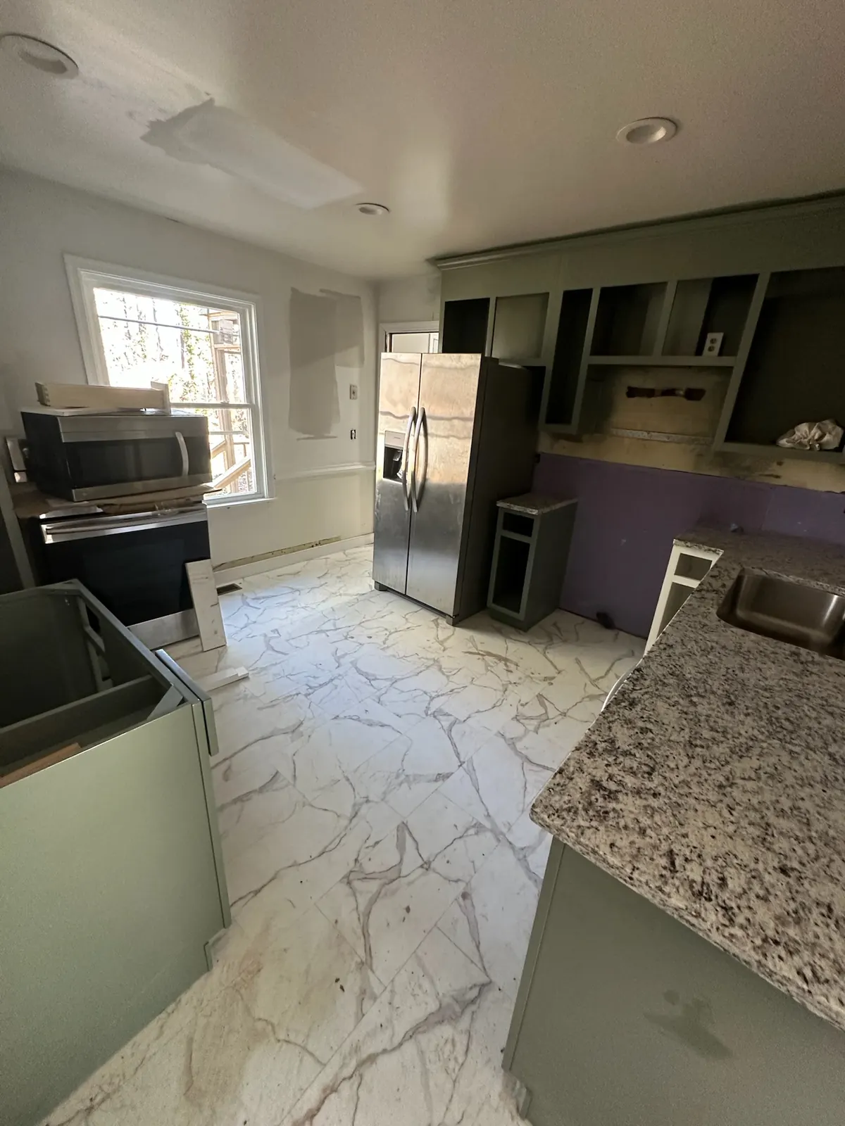 Kitchen at Kingsland Rd mid-renovation with appliances staged and flooring in progress