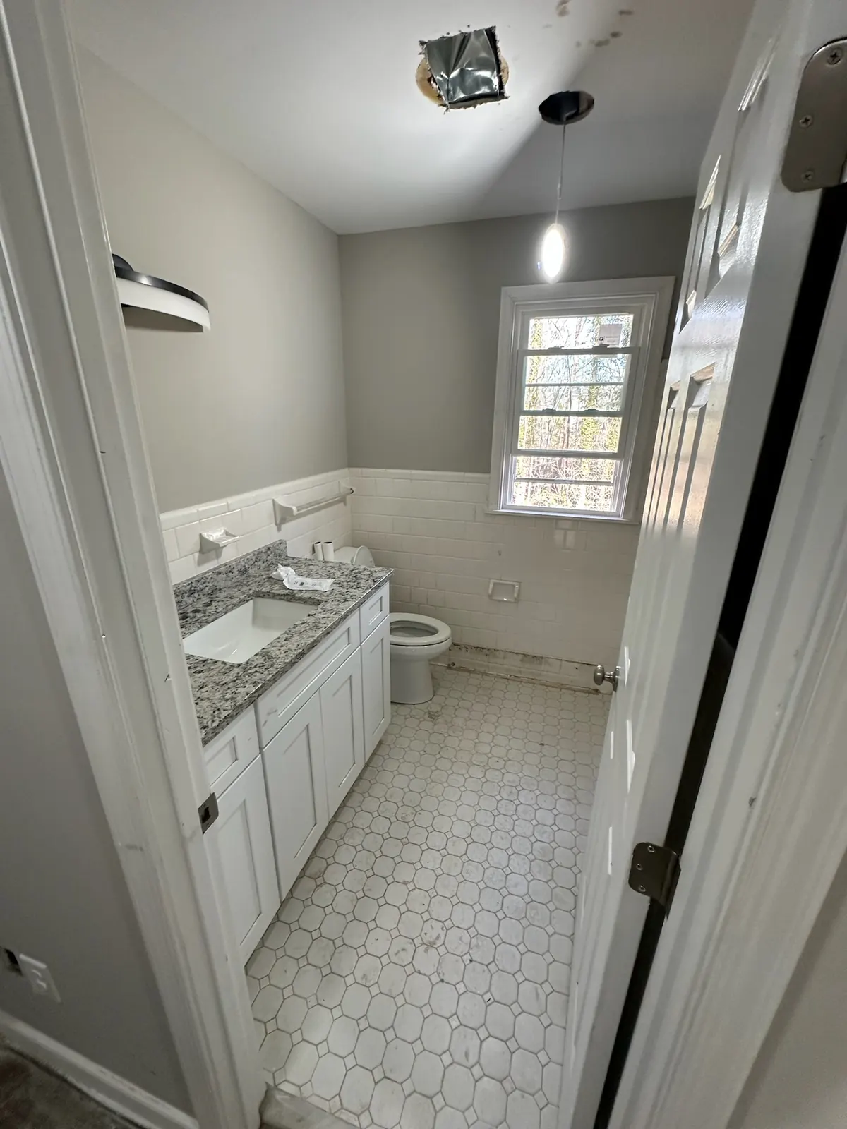 Kingsland Rd bathroom in progress with new white vanity and granite counter installed