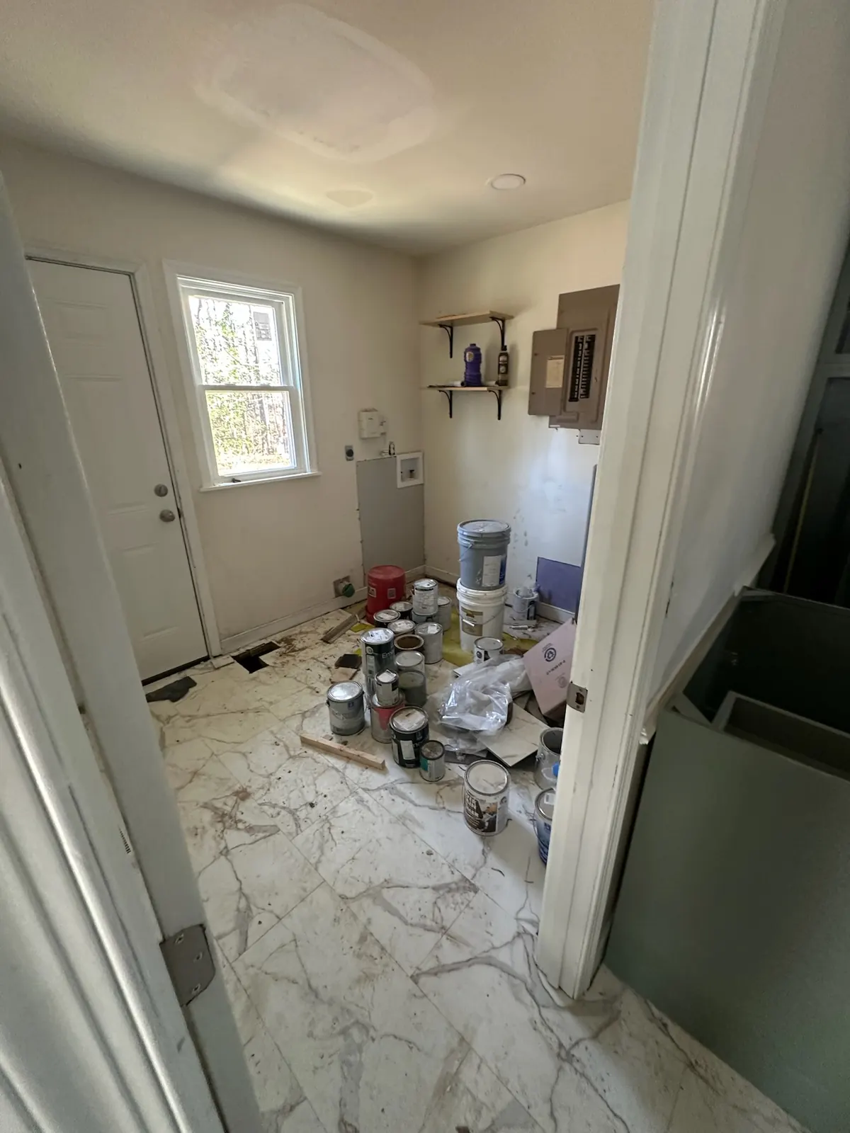 Utility room at Kingsland Rd mid-renovation with supplies staged on new flooring